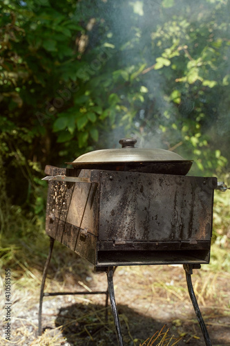Porridge on the fire. Picnic and food in nature. Lifestyle. Vertical orientation, copy spase, dark moody photo.