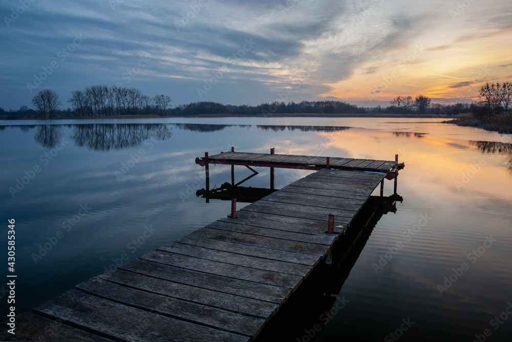 Wooden pier on a calm lake and evening clouds, Stankow, Poland