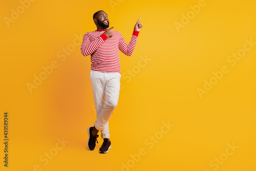 Photo of man indicate forefinger empty space on yellow wall