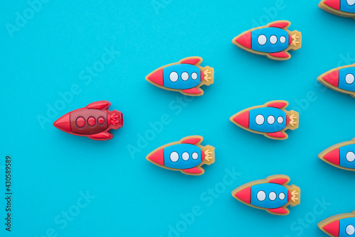 Leadership concept. Red rocket leading among small blue rockets on blue background. Leadership skills need for top management in organization, company ex: supervisor, manager, CEO, CFO.