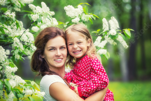 Portrait of happy mother and little daughter in spring park