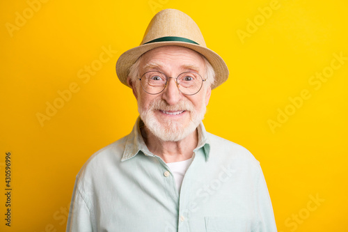 Photo of charming positive mature man dressed green shirt cap glasses smiling isolated yellow color background © deagreez