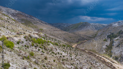 Dramatic clouds on the sky in mountains. Aerial drone view of dark and stormy above hills. Thunderstorm in nature. Cloudscape.  Approaching storm and rain.  © Ajdin Kamber