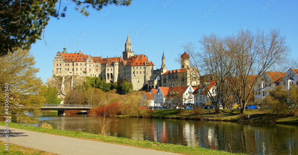 herrliches Schloss Sigmaringen spiegelt sich unter blauem Himmel vor grünen Ufer des Donau  Radweges