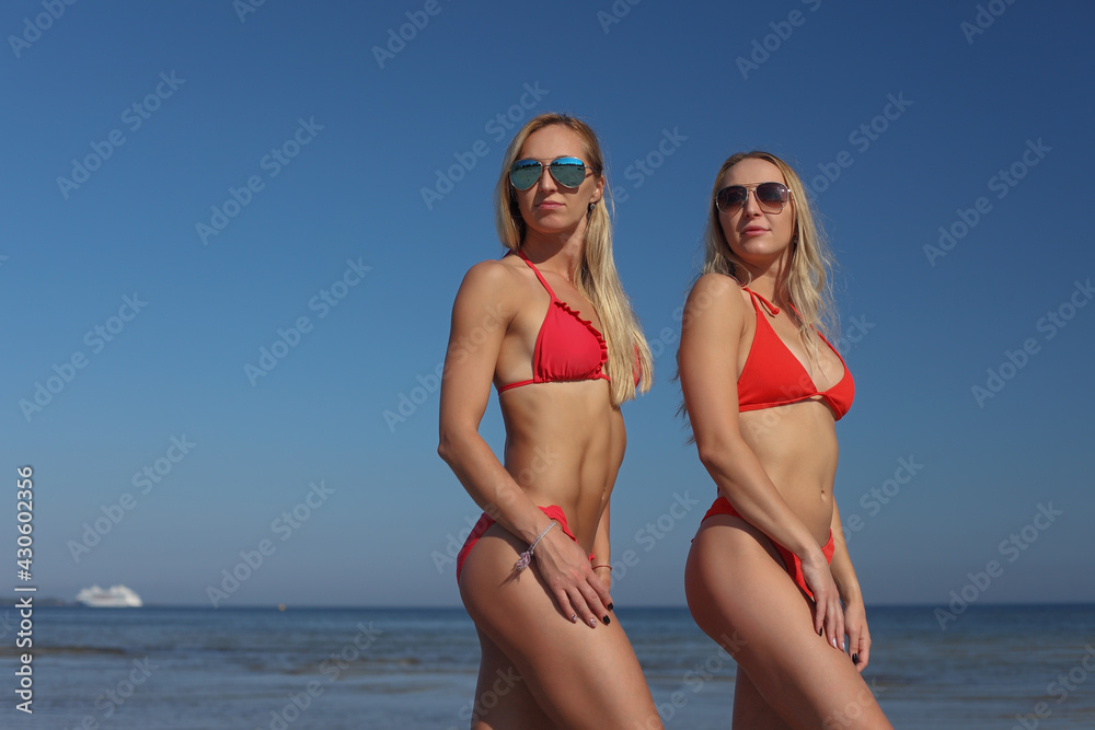 young women girlfriends in bikini on a beach