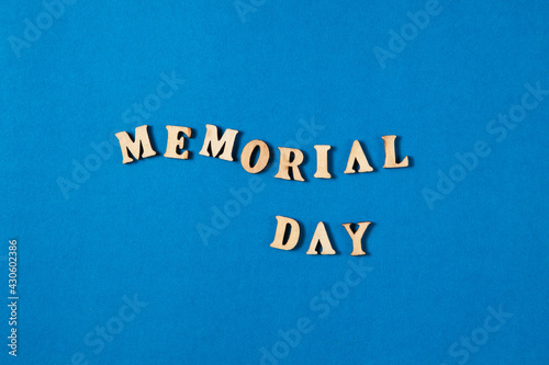 Memorial Day text made from wooden letters on blue background