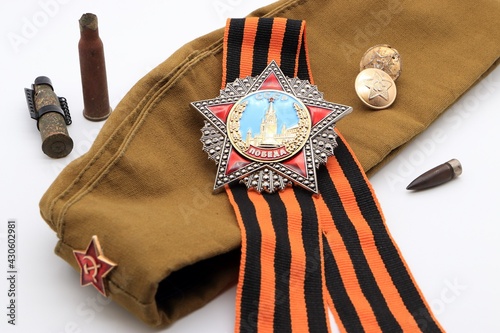 Military cap with a red star, the order of Victory on the St. George ribbon, uniform buttons and cartridge cases on a white background photo