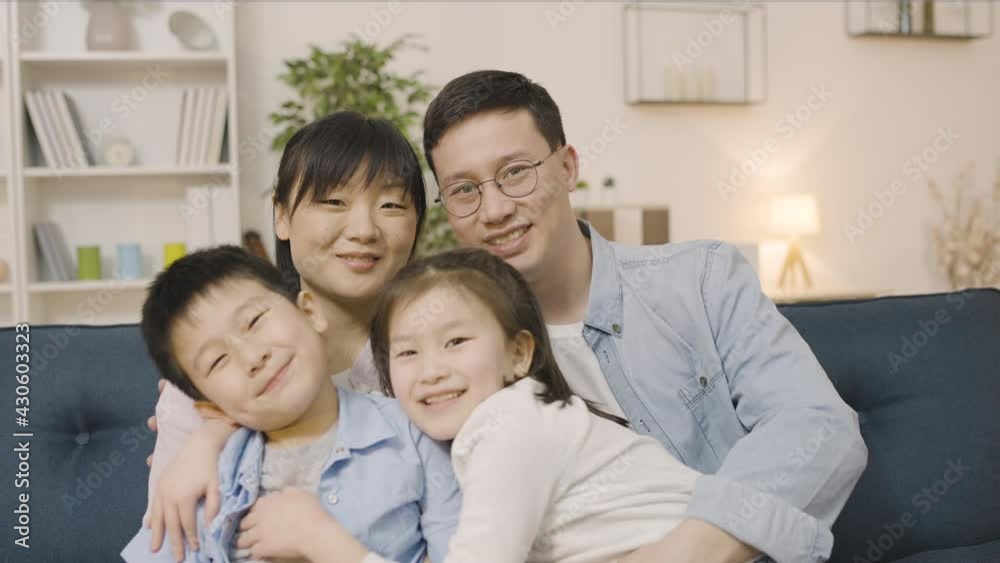 Portrait of happy asian family, parents and two kids smiling and hugging in cam Portrait of happy asian family, parents and two kids smiling and hugging in cam