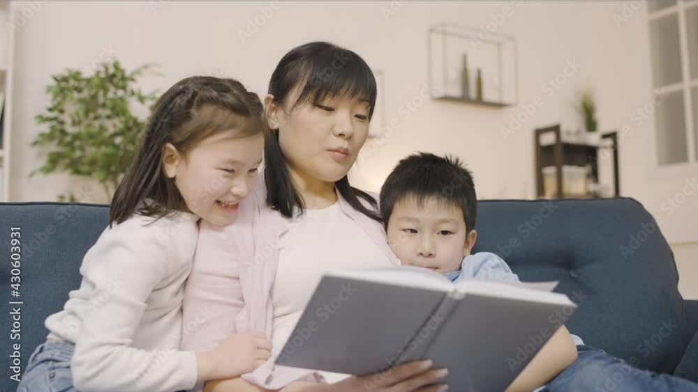 Loving mother reading book to son and daughter, family enjoying leisure together Loving mother reading book to son and daughter, family enjoying leisure together