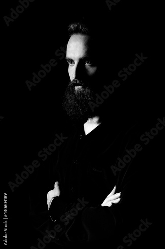 Low key dramatic photo of a bearded man