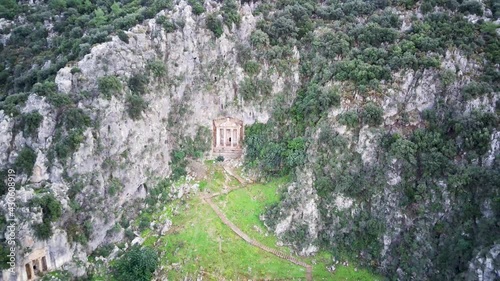 Drone view on world famous unesco Tomb of Amyntas in Fethiye. Rock cutted lucian empire tombs inside the green mountain
 photo