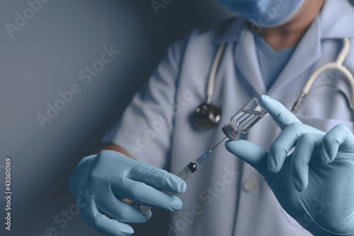  doctor or scientist in laboratory holding a syringe with liquid vaccines for children or older adults,Concept:diseases,medical care,science.,Concept fight against virus covid-19 corona virus.