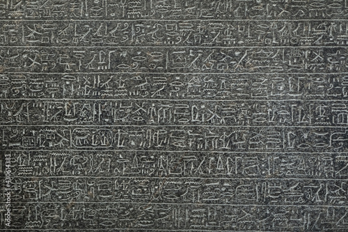Egyptian hieroglyphs marks on the grey tomb wall.