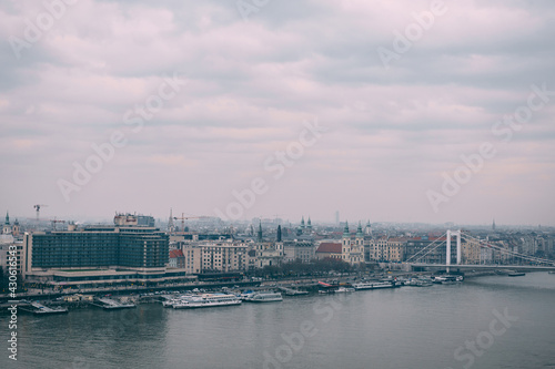 View of the bridge over the Danube river against the background of old houses in Budapest