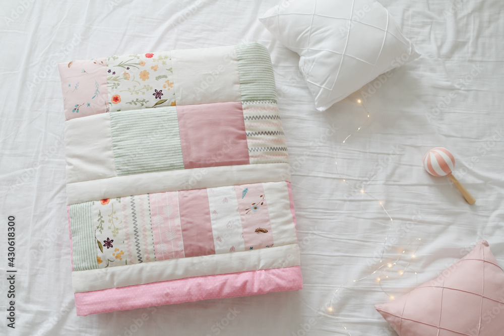 Cozy baby cot with a patchwork blanket. Baby bedding and textile for nursery Cozy baby cot with a patchwork blanket. Baby bedding and textile for nursery