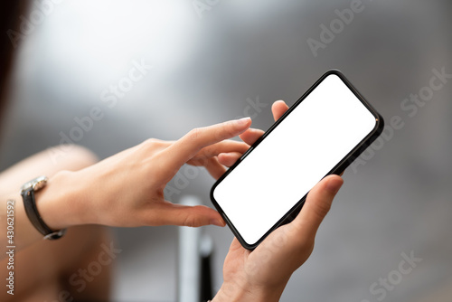 Close up woman hand holding a smartphone blank white screen.