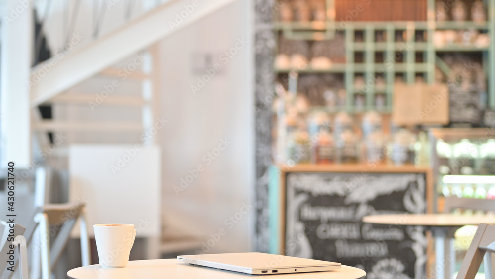 Closed Laptop on Table in Coffee Shop Closed Laptop on Table in Coffee Shop