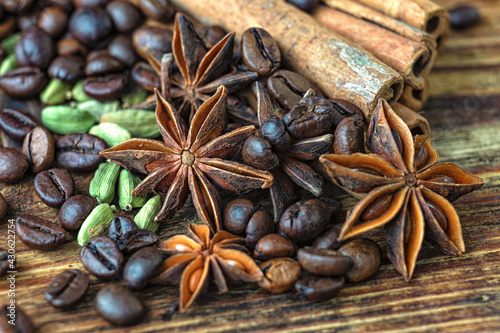 Anise stars, cinnamon, cardamom and roasted coffee beans on a wooden table. 