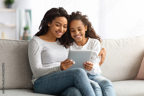Happy african american mother and kid using digital tablet together