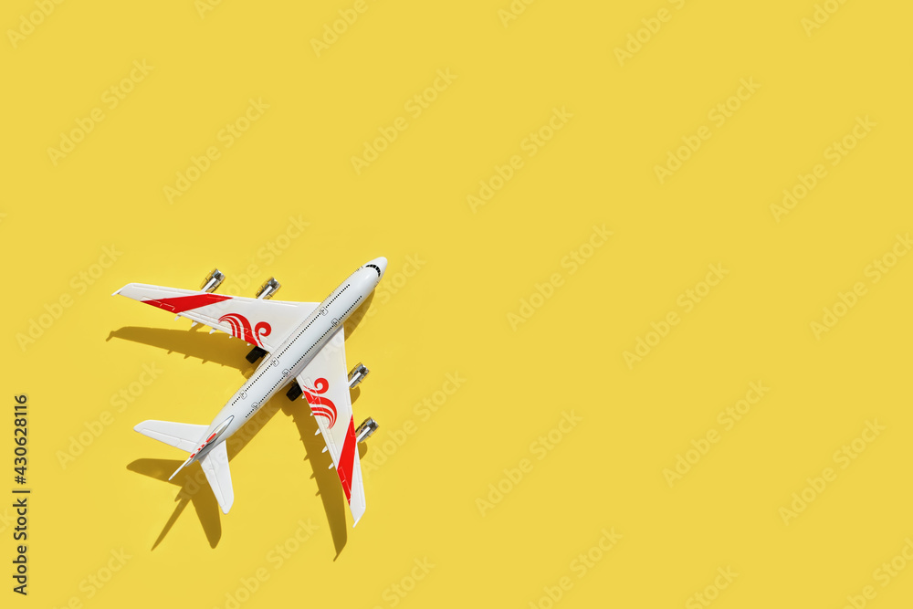 Model of a toy airplane of white color on a yellow background Model of a toy airplane of white color on a yellow background