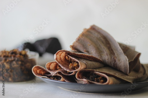 Finger millet crepes with freshly grated coconut and palm jaggery filling photo