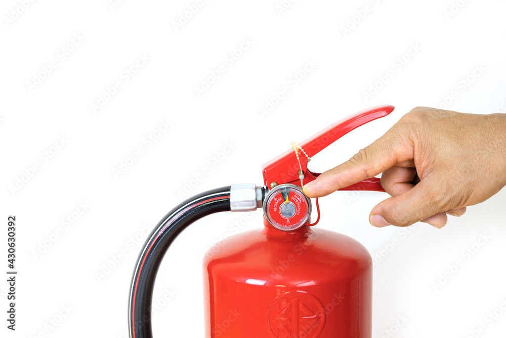 The man's hand pointed to the gauge of the red fire extinguisher,.dry chemical fire extinguishers, The use of fire extinguishers, The availability, training, fire, office, safety. isolated on white. The man's hand pointed to the gauge of the red fire extinguisher,.dry chemical fire extinguishers, The use of fire extinguishers, The availability, training, fire, office, safety. isolated on white.