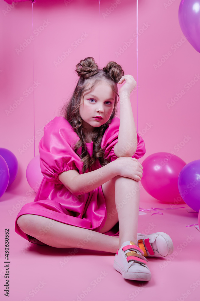 attractive brunette girl model with pink make up and in pink leather dress near colorful balloons on pink background.concept of joy, party, birthday. attractive brunette girl model with pink make up and in pink leather dress near colorful balloons on pink background.concept of joy, party, birthday.