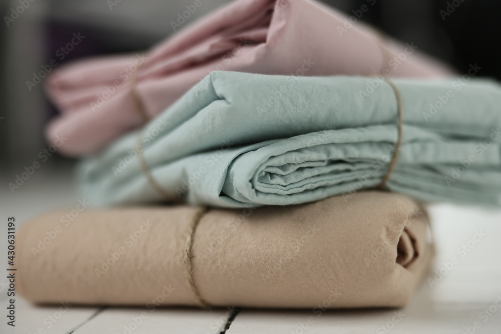 photo with 3 colors (pink, mint, beige) of natural and ecological washed cotton fabrics stacked on top of each other on white background