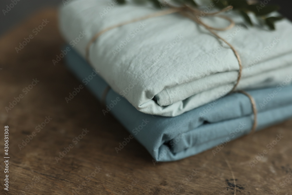 photo of 2 natural and ecological washed cotton fabrics in mint and turquoise colours rewound with sack thread and green plant on it photo of 2 natural and ecological washed cotton fabrics in mint and turquoise colours rewound with sack thread and green plant on it