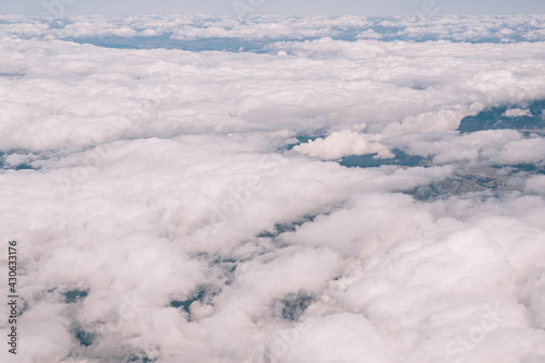 View from the window of the plane on the white cumulus clouds in the sky