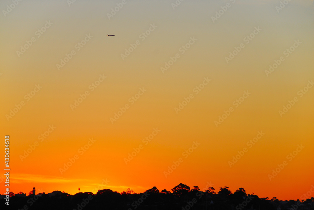 A plane departs from Sydney Kingsford Smith Airport on a beautiful summer evening in Australia. A plane departs from Sydney Kingsford Smith Airport on a beautiful summer evening in Australia.