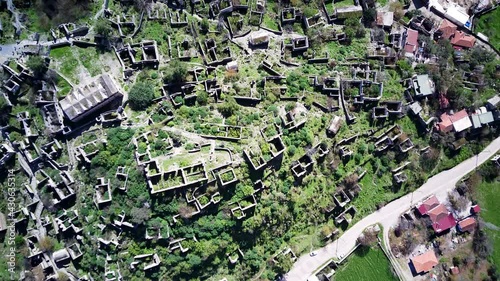 Drone view on world famous Kayakoy ghost town near to Olludeniz, Fethiye. The old ancient city on the beautiful green slope of the hill.
