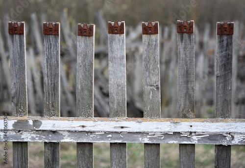 old unpainted wooden fence made of narrow boards in the country