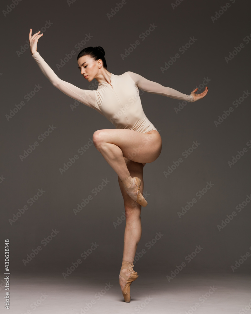 Obraz premium Young beautiful skinny ballerina is posing in studio