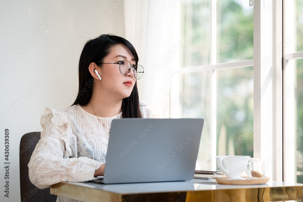 Happy of asian freelance people Businesswoman wearing wireless earphones casual working with laptop computer with a coffee cup mug,Notebook and smartphone at the cafe,Business Lifestyle communication Happy of asian freelance people Businesswoman wearing wireless earphones casual working with laptop computer with a coffee cup mug,Notebook and smartphone at the cafe,Business Lifestyle communication