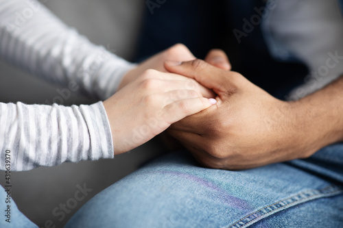 Closeup Shot Of Black Man And White Woman Holding Hands Together
