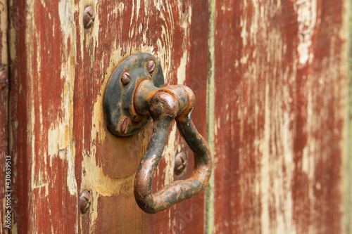 old and rusted door handle on a brown painted wooden door © Ian