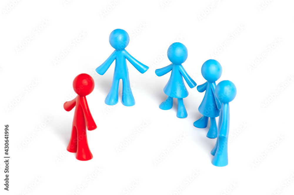 . Toy people Isolated on white background. The red man stands apart from the group. Asociality, sociopathy. Rejected by society, lonely. Development of leadership and social qualities. . Toy people Isolated on white background. The red man stands apart from the group. Asociality, sociopathy. Rejected by society, lonely. Development of leadership and social qualities.