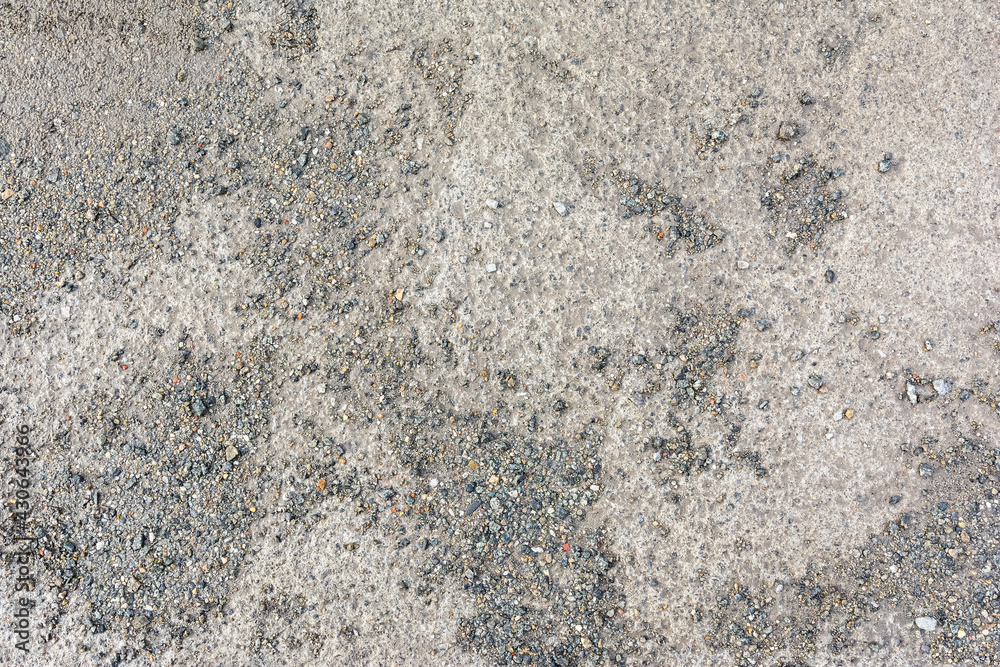 the muddy concrete road is covered with fine gravel chips as a natural backdrop the muddy concrete road is covered with fine gravel chips as a natural backdrop