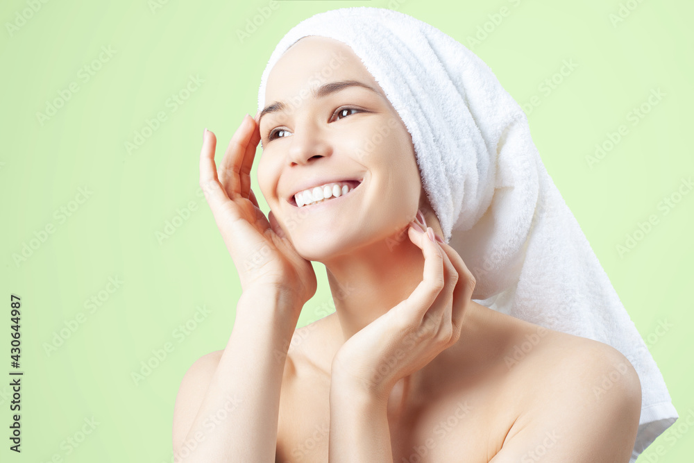 Cute positive girl in towel on her hair on green background Cute positive girl in towel on her hair on green background