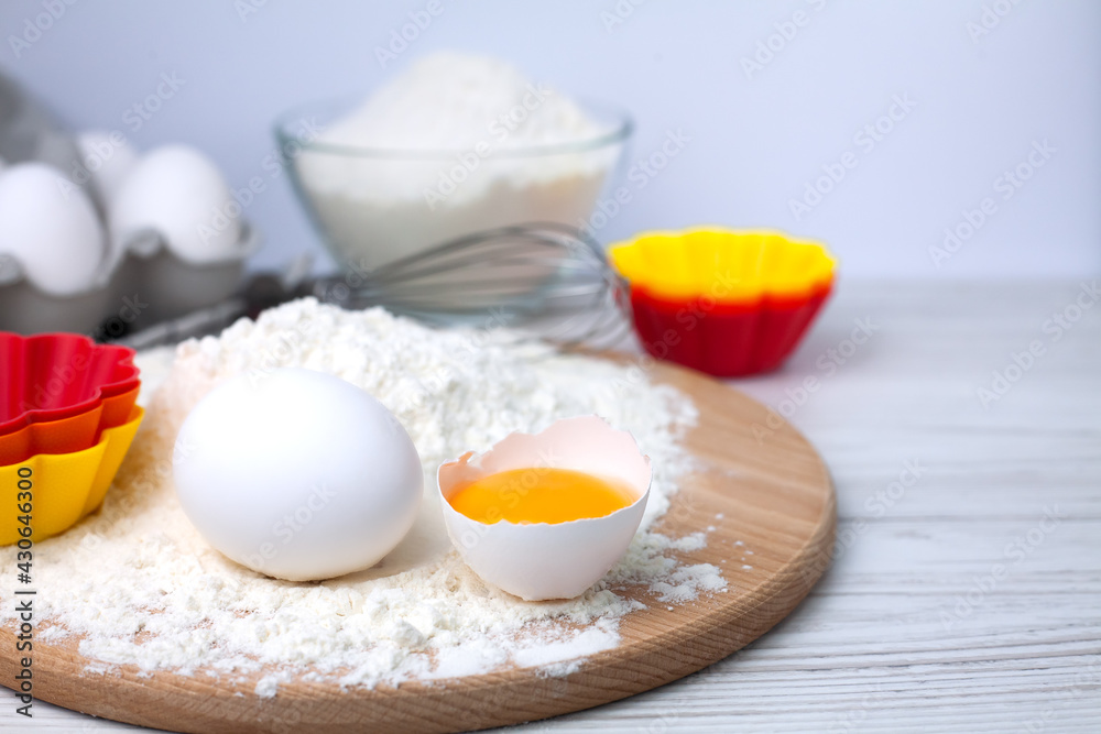 Ingredients for baking cupcakes for the holiday. Flour, eggs and multicolored silicone form on a table. Close-up. Copy space. Ingredients for baking cupcakes for the holiday. Flour, eggs and multicolored silicone form on a table. Close-up. Copy space.