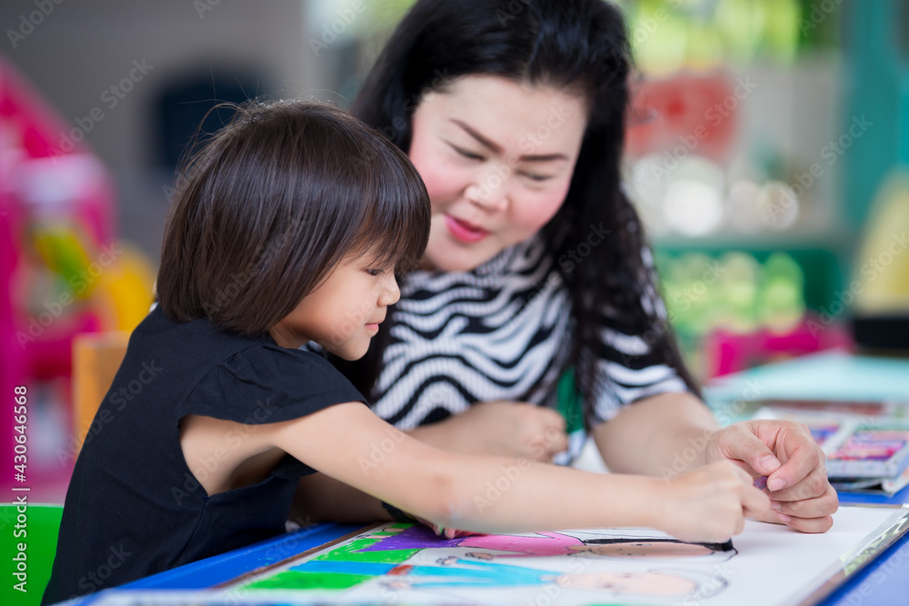 Mom gave her daughter some advice for making crafts. Doing activities together in the family. Girl happily made art. Child smiles sweetly. Kid wearing black shirts aged 5-6 years. Homework. Stay home. Mom gave her daughter some advice for making crafts. Doing activities together in the family. Girl happily made art. Child smiles sweetly. Kid wearing black shirts aged 5-6 years. Homework. Stay home.