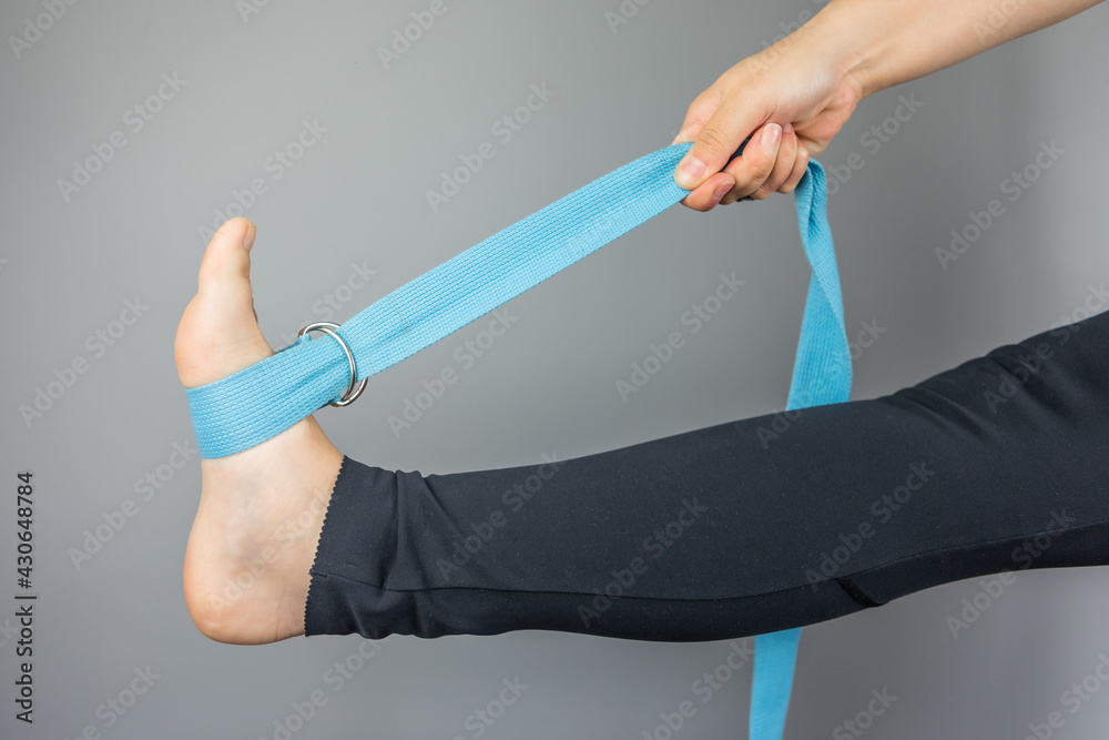 Leg stretching with tape. Adjustable yoga stretch strap. Flexibility  training aid. Stock Photo