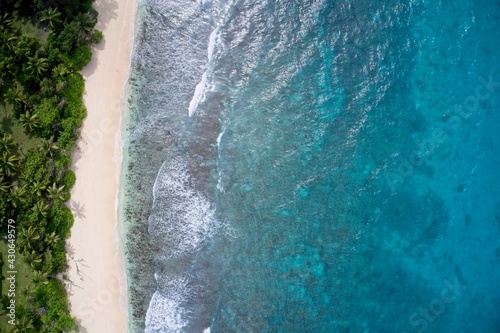 Drone field of view of empty coastline and waves meeting beach Praslin, Seychelles.