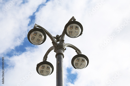 Street lantern with led lamps on background of blue sky and white clouds. Electric lighting, energy-saving illumination