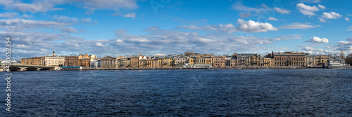 Amazing Panorama of St. Petersburg, Russia. River Neva granite embankment. Sunny spring day. On the horizon are famous historical buildings on white clouds background. View from "Vasilievsky Island". © GenоМ.