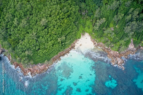 Drone field of view of turquoise blue waters and coastline of cliffs Praslin Seychelles.