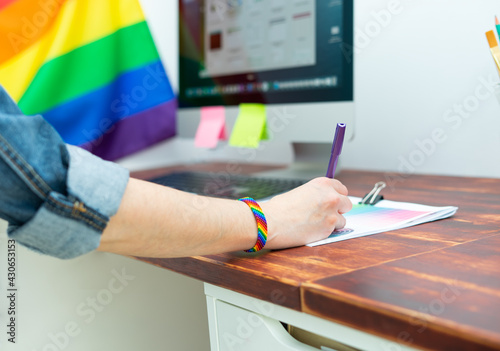 Cultura LGBTQIA. Woman working in office with LGBT accessories.