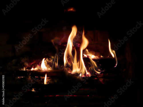 Fire burning in fireplace, close up of orange flames eating firewood