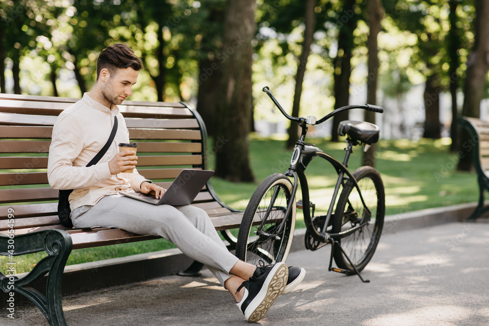 Work with pleasure. Side view of handsome man with stubble in casual clothes, typing on laptop Work with pleasure. Side view of handsome man with stubble in casual clothes, typing on laptop